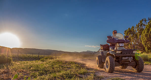 istock ATV on dirt road at sunset 596055288