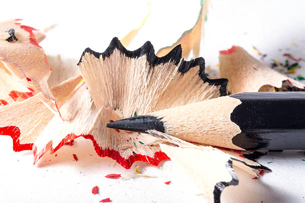 istock Black  pencil with colorful shavings, white background texture close-up 596056294