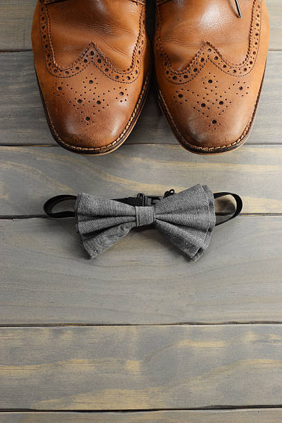 istock Vertical arrangement of wingtips shoes and bowtie 596059464