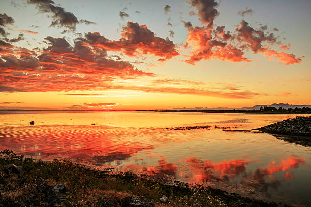 istock red sunset clouds reflecting on sea water 596061932