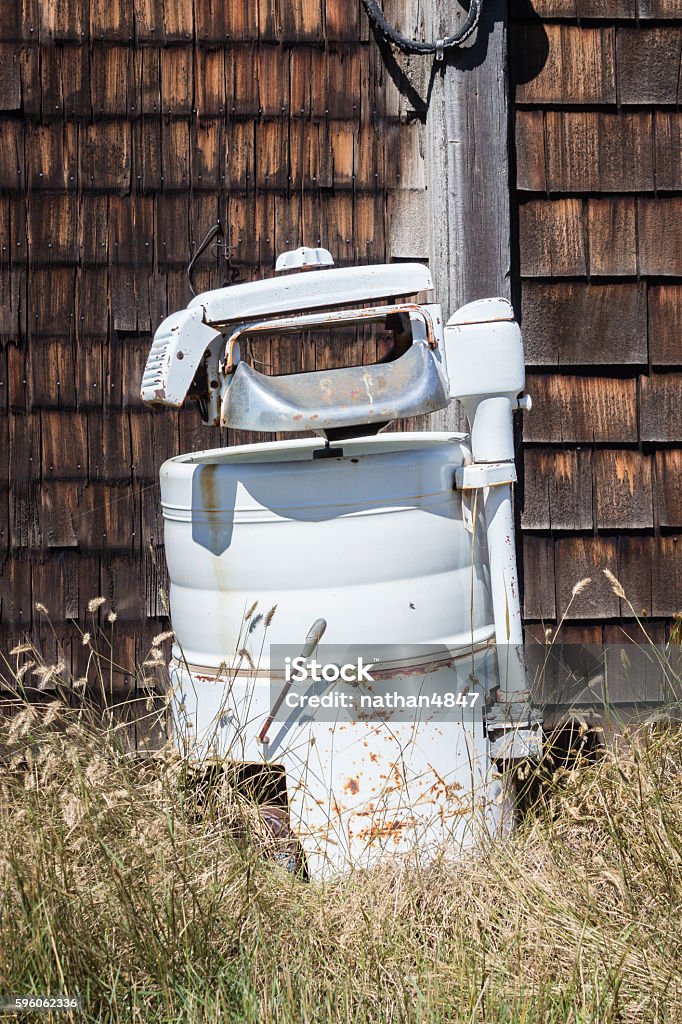 old vintage antique wringer washing machine. vertical image of an old fashioned antique wringer washer sitting in dead grass outside the home. 19th Century Stock Photo
