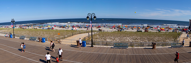 Ocean City, New Jersey, USA - August 4, 2016: Panoramic vier of the the Ocean City boardwalk and beach with tourist enjoyng a beautiful summer day in New Jersey. Ocean City is a major summer vacation destination on the east coast.