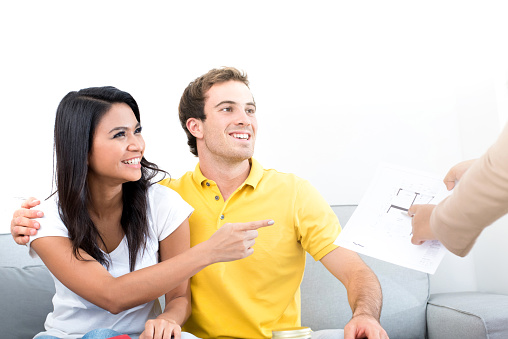 Young interracial couple meeting with  real estate agent at home