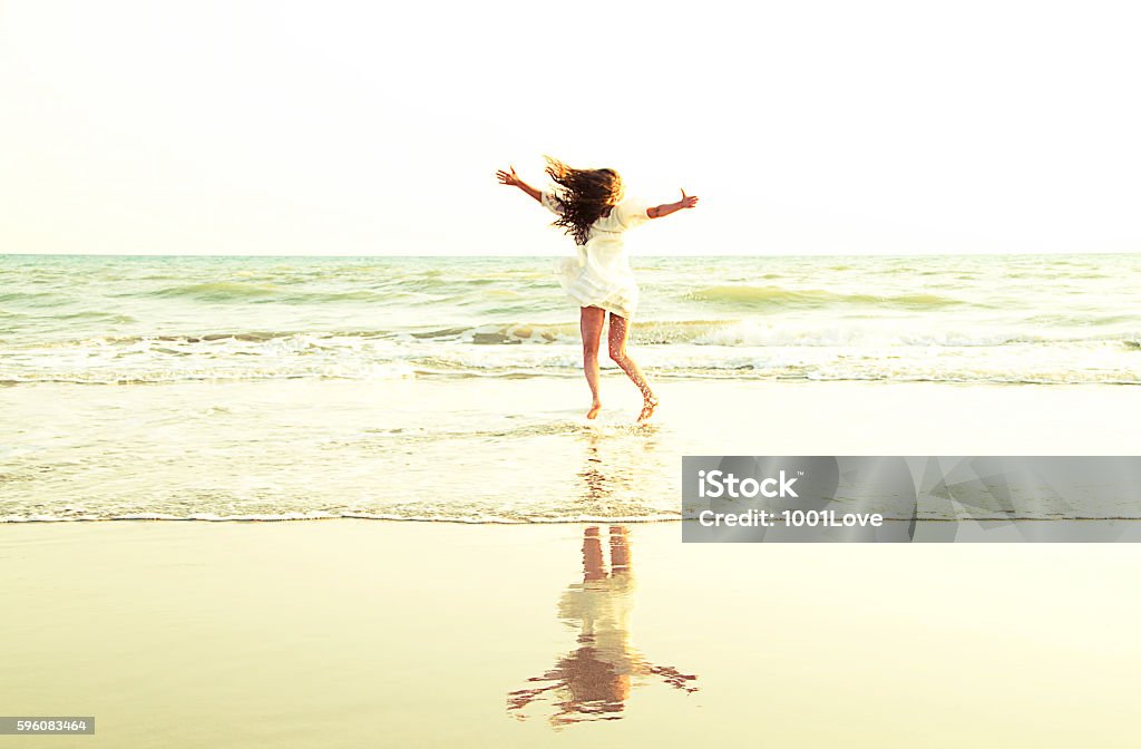 Summer Time - Freedom calls woman having fun at sea and running to the sun. Summer Time. Adult Stock Photo