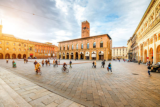 Maggiore square in Bologna city Bologna, Italy - May 23, 2016:People walk on Maggiore square with Podesta palace in the center of Bologna city in Italy bologna photos stock pictures, royalty-free photos & images