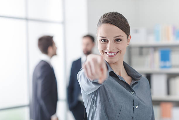 istock Smiling businesswoman pointing at camera 596089910