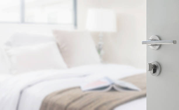 istock opened white door to bedroom with reading lamp and book 596092820