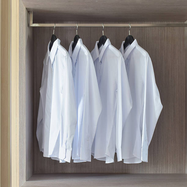 istock Classic white shirts in warm wooden wardrobe 596092932