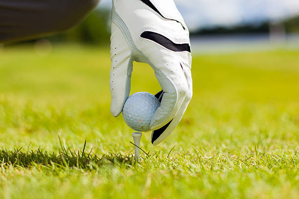 istock Hand hold golf ball with tee on course, close-up 596095416