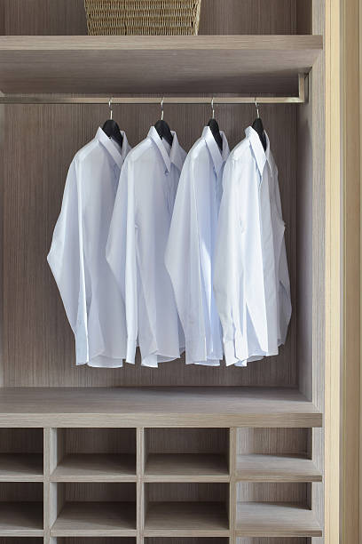 istock Classic white shirts in warm wooden wardrobe 596095436