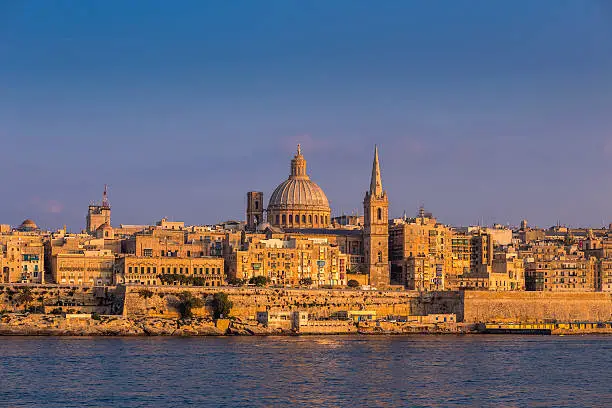 Valletta, Malta - The famous St.Paul's Cathedral and the ancient city of Valletta at sunset with clear blue sky