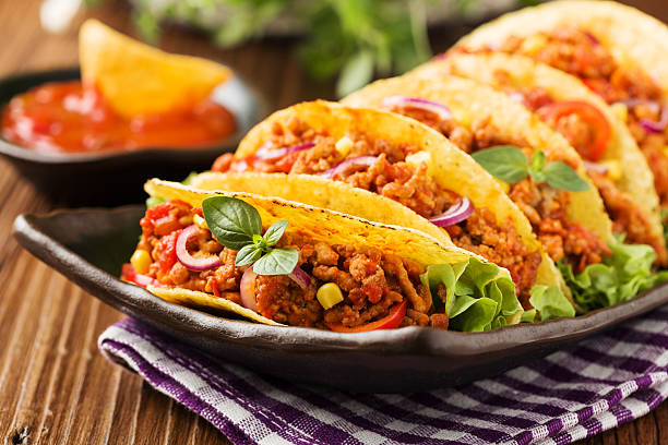 istock Tacos with meat and vegetables on wooden board 596337344