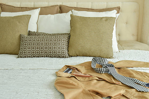 istock Yellow suit and tie on bed with brown pillows 596337364