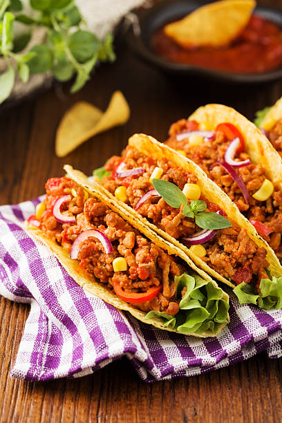 istock Tacos with meat and vegetables on wooden board 596337496