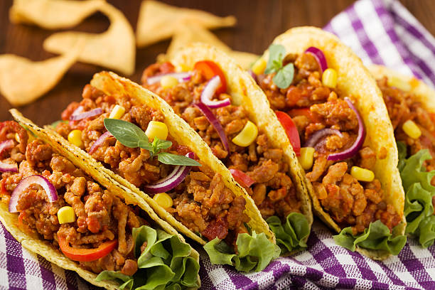 istock Tacos with meat and vegetables on wooden board 596337580