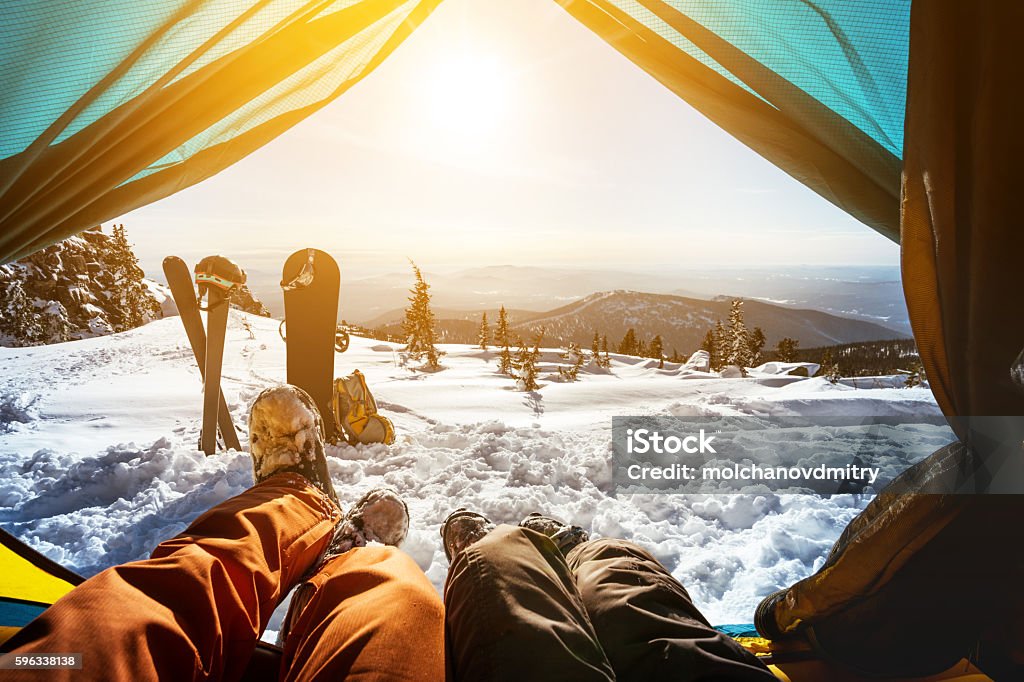 Couple of snowboarder and skier in tent Couple of snowboarder and skier having rest in tent on the top of mountain Snowboarding Stock Photo