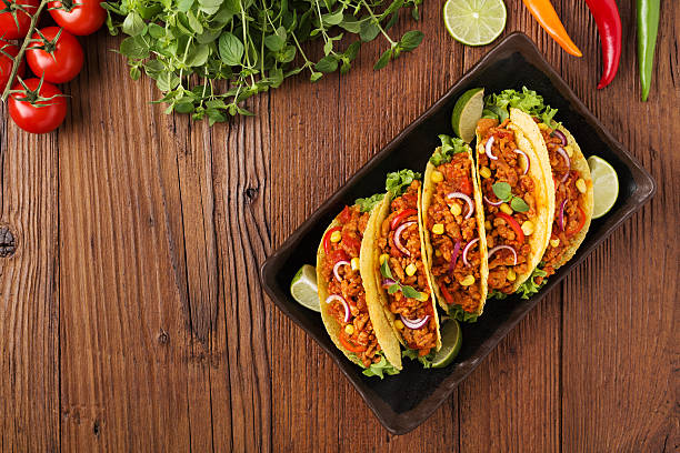istock Tacos with meat and vegetables on wooden board 596339268