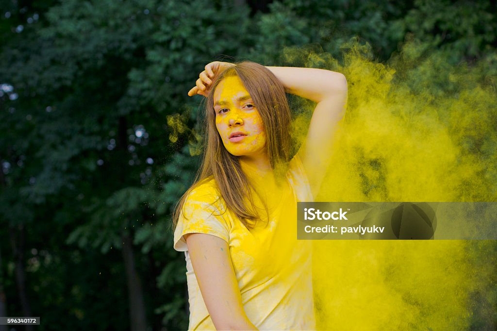 Beautiful brunette woman with yellow paint Holi Beautiful brunette model with yellow paint Holi 20-29 Years Stock Photo