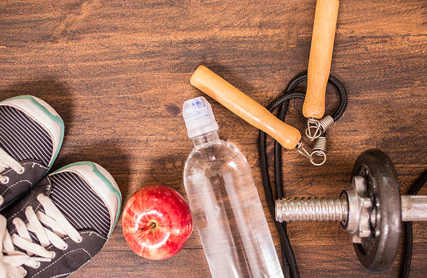 istock Fitness, exercise themed scene with weights, sneakers, apple. 596340862