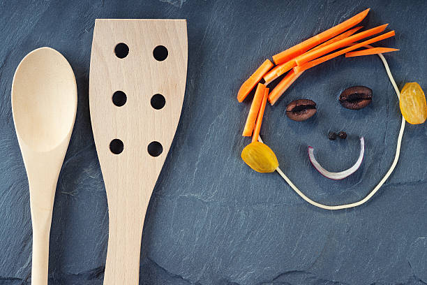 istock Wooden kitchenware and smiley face made from vegetables 596341914