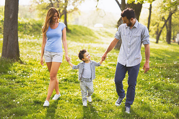 istock Young happy family walking through the park holding hands. 596343408