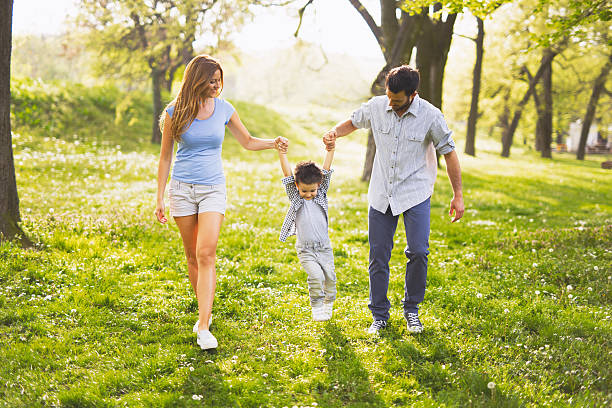 istock Parents swinging their little boy outdoors and having fun. 596343472