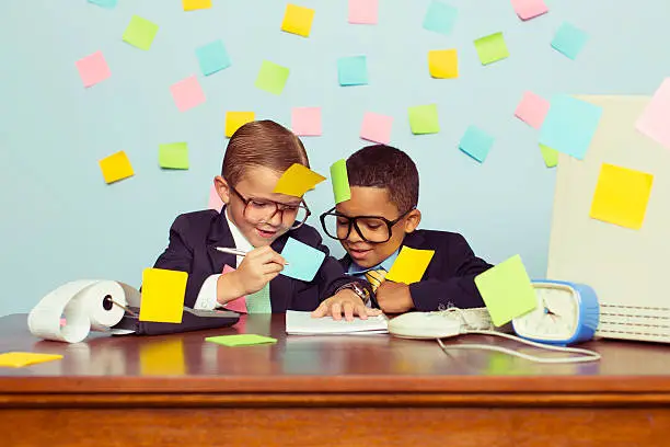 Photo of Two Young Businessmen at Desk Covered with Sticky Notes