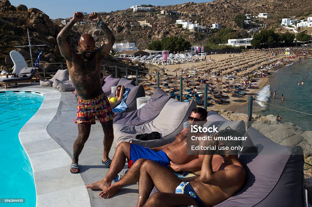 Gay people have fun on the Super Paradise Club. Mykonos, Greece - June 15, 2014 : Gay people have fun on the Super Paradise Club. Mykonos Island. Gay Person Stock Photo