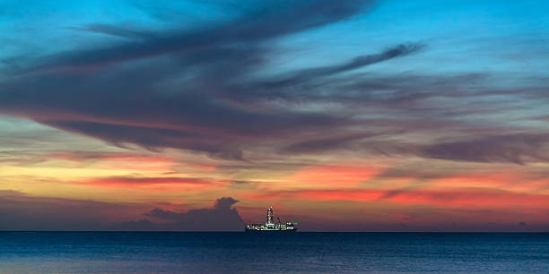 Drillship illuminated under amazing colorful twilight skyscape Illuminated oil drilling ship cruising at the horizon under amazing colorful twilight skyscape. Indian Ocean, Africa. night sky only stock pictures, royalty-free photos & images