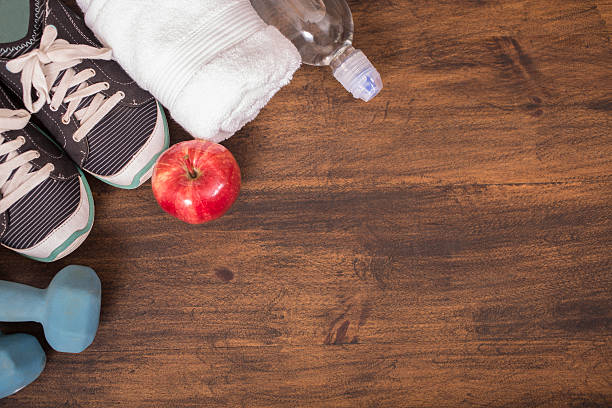 istock Fitness, exercise themed scene with weights, sneakers, apple. 596347502