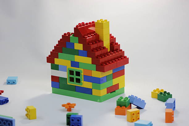 Colorful toy house with bricks in mess stock photo