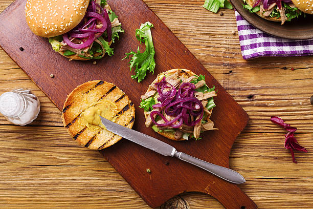 istock Burger with meat of duck with red onion and lettuce. 596351120