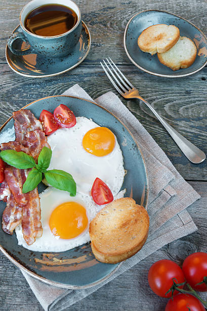 istock Fried eggs,  bacon, tomato, toast and a cup of coffee 596351132