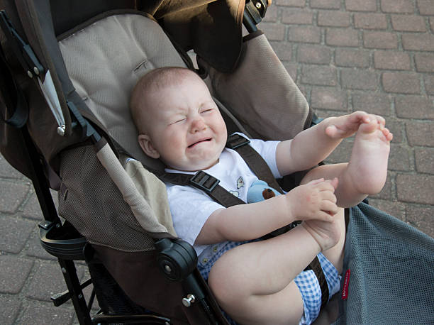 Little baby is crying in baby carriage stock photo