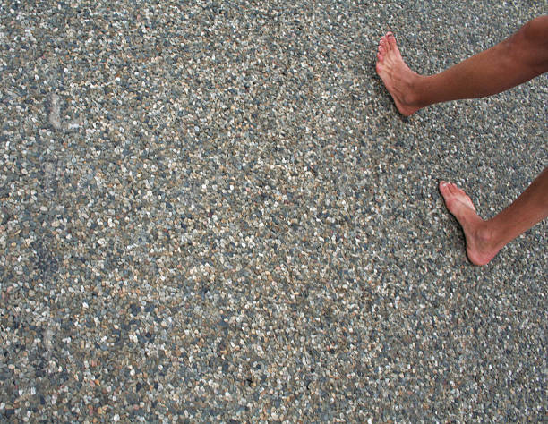 Feet walking on asphalt road. stock photo