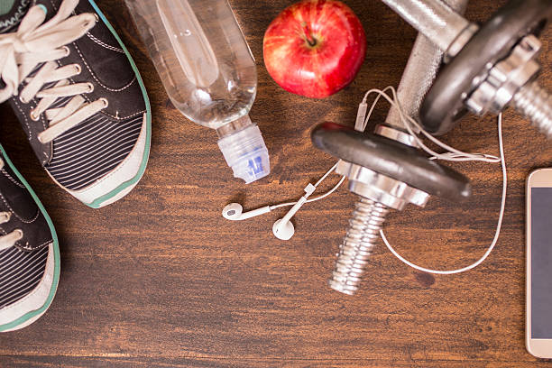 istock Fitness, exercise themed scene with barbells, sneakers, earbuds. 596353744