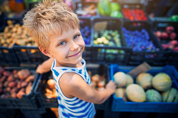 kleiner junge auf dem italienischen bauernmarkt - local market stock-fotos und bilder