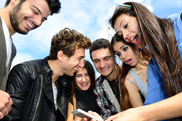 Six young adults around phone