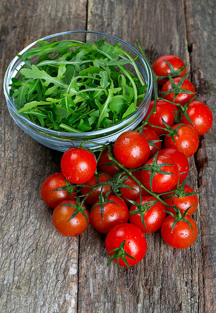 istock fresh rucola and cherry tomatoes on wooden surface 596360288