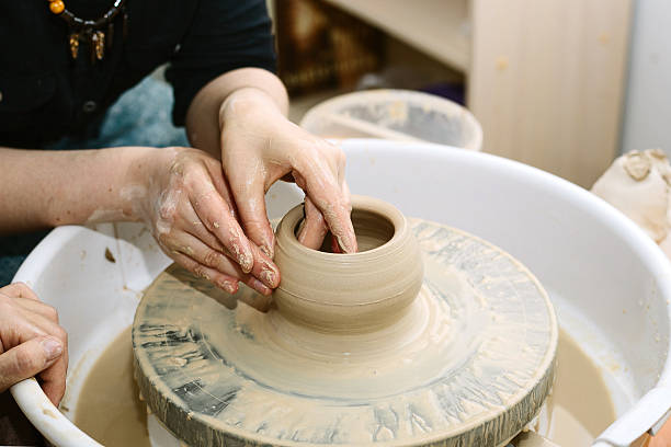 istock the teacher teaches the student work on the potter's wheel. 596361100