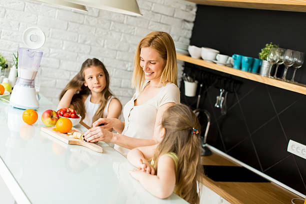 istock Woman and two girls in the kitchen 596361766