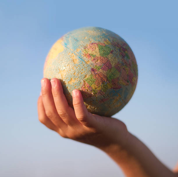 istock Child hand holding an earth toy globe 596363108
