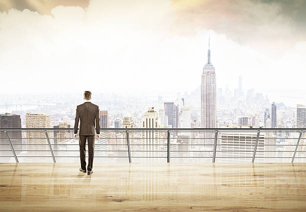 istock Businessman in suit looking at city 596364218
