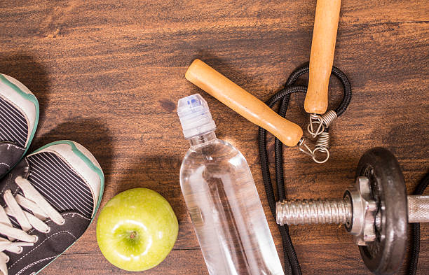 istock Fitness, exercise themed scene with weights, sneakers, apple. 596366646