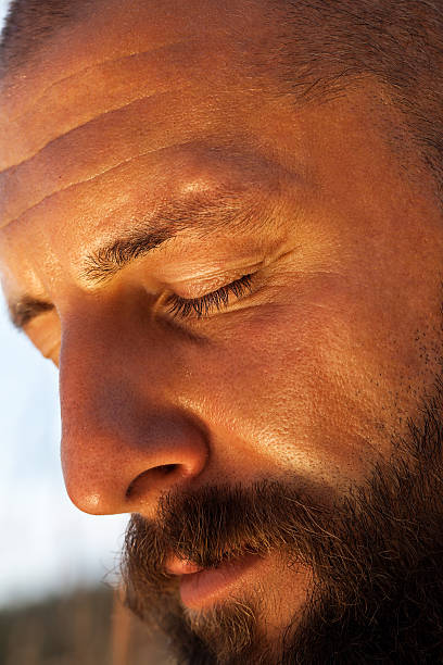 istock man with his eyes closed meditatively in an early morning 596367314