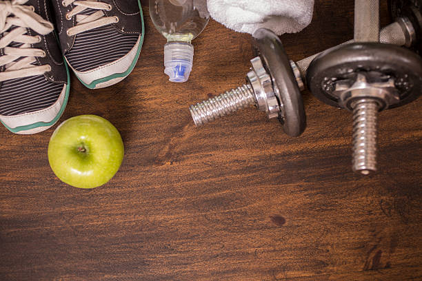 istock Fitness, exercise themed scene with weights, sneakers, apple. 596368256
