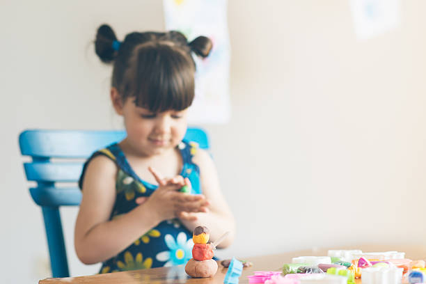 istock Cut girl playing with play dought in her home 596368456