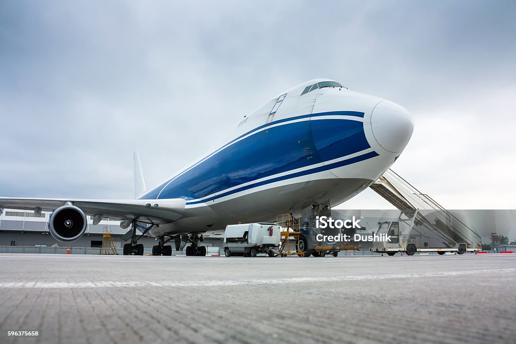 Cargo wide-body plane and aircraft passenger loader near terminal - Royaltyfri Lastcontainer Bildbanksbilder