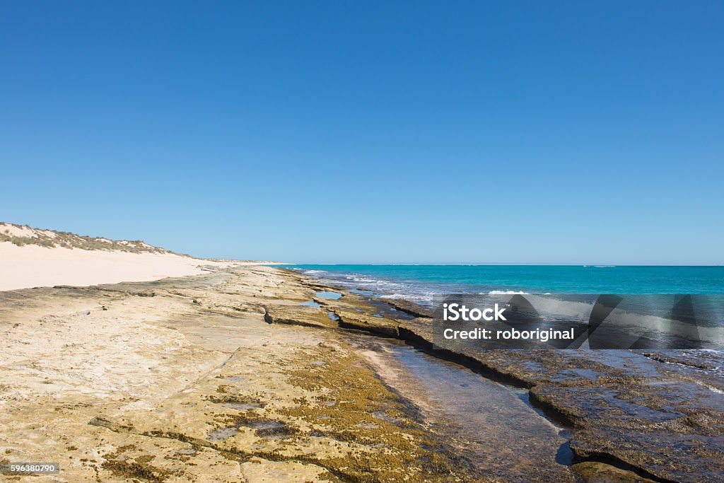 Ningaloo Reef Coast Cape Range Australia Rocky beach along Ningaloo Reef coast at Cape Range National Park, Exmouth, Western Australia, with dunes, horizon, turquoise ocean water, blue sky and copy space. Ningaloo Reef Stock Photo