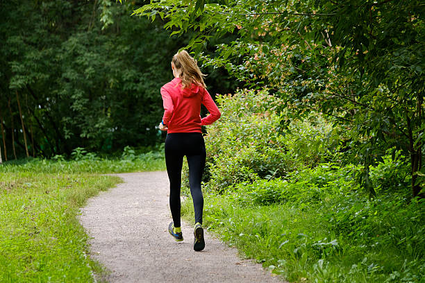 istock Young woman jogging in the park 596382646